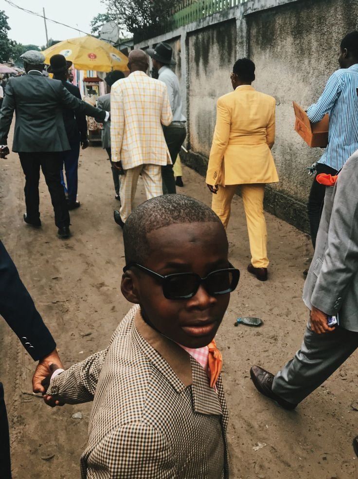 A sharply dressed child walking through a busy street